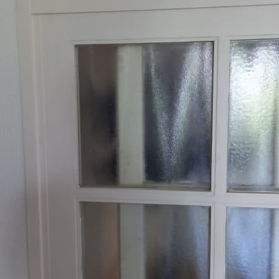 זכוכית מחוספסת במסגרת חלון לבנה