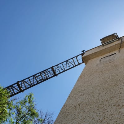 סולם מתכת מחובר לבניין גבוה בשמיים כחולים