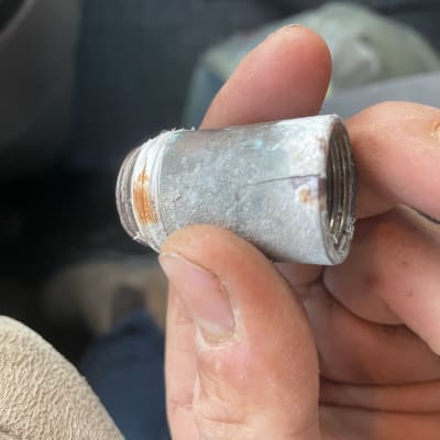 חלק צינור מתכת חלוד ביד של אדם