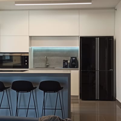 מטבח מודרני עם מקרר, תנור, כיור וכיסאות בר