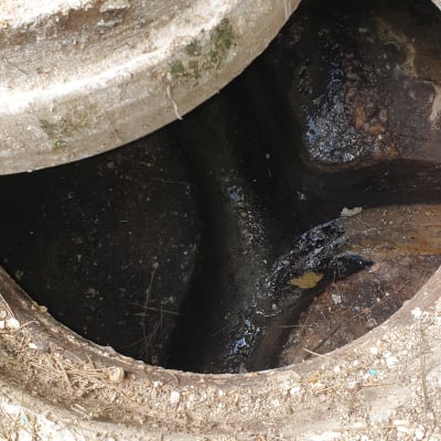 פתח ביוב עם מכסה בטון פתוח חלקית