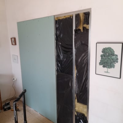 קיר גבס בבנייה עם בידוד שחור וצהוב