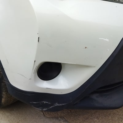 פגוש רכב לבן עם שריטות ופגמים