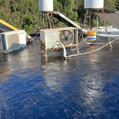 גג אטום בזפת עם דודי שמש ומזגן