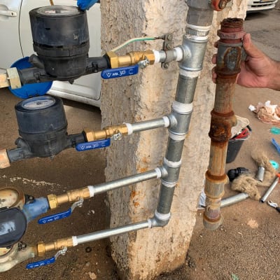 צנרת מים עם ברזים ומדי מים מותקנים על קיר