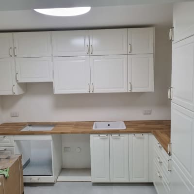 מטבח חדש עם ארונות לבנים ומשטחי עץ