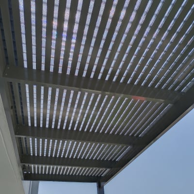 פרגולה מאלומיניום עם קורות מקבילות בשמיים בהירים