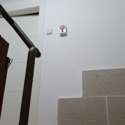 קיר צבוע בלבן עם מתג וידית מעקה