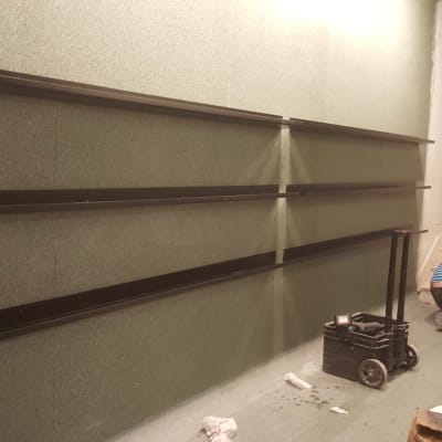 שלושה מדפים שחורים מותקנים על קיר ירוק