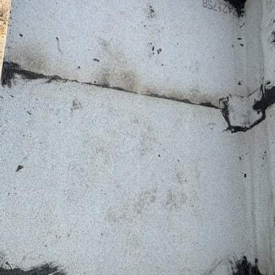 איטום פינות עם חומר שחור על משטח אפור