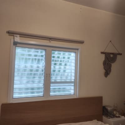 חלון עם תריסים מותקנים ומוט וילון מעל