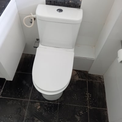 אסלה לבנה עם צינור מים מחובר