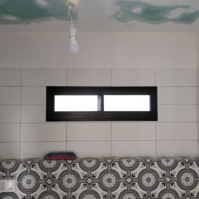 חלון אלומיניום שחור על קיר לבן