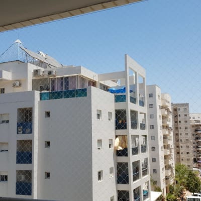 רשת נגד יונים מותקנת על מרפסת בניין