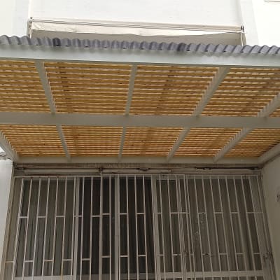 פרגולה מאלומיניום עם גג שקוף מעל חצר