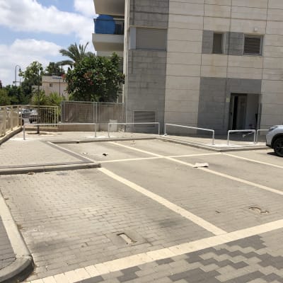מסגרות מתכת סביב חניות ריקות במגרש חניה
