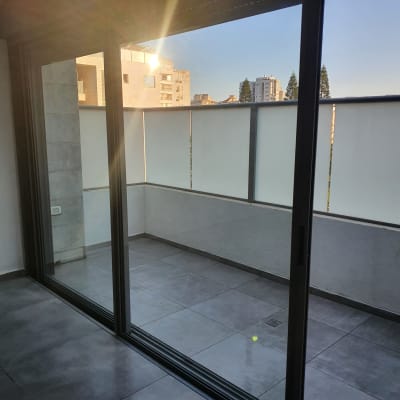 מרפסת נקייה עם רצפת אריחים ודלת זכוכית