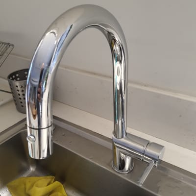 ברז נירוסטה מעל כיור מטבח עם סמרטוט צהוב