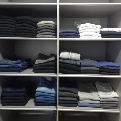 בגדים מקופלים בארון מסודר על מדפים