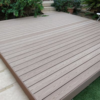 דק עץ בגינה עם צמחייה מסביב