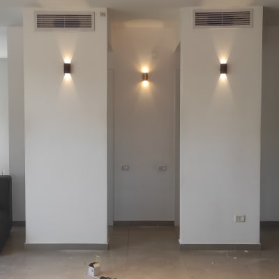 סולם עץ ליד קיר עם גופי תאורה דולקים