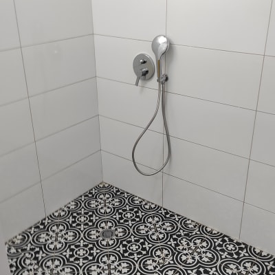 מקלחת עם אריחים לבנים וראש מקלחת כסוף