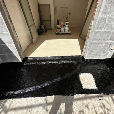 איטום רצפה עם חומר שחור בכניסה לבניין
