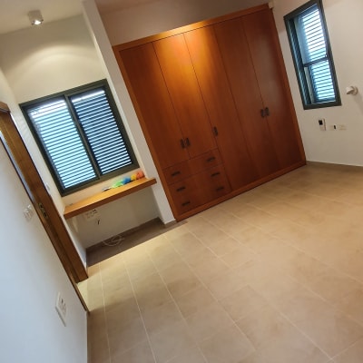 מנקה אבק צבעוני מונח על מדף ליד חלון