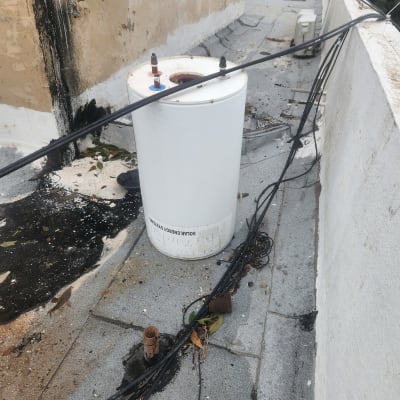 דוד שמש לבן על גג עם צינורות חשופים