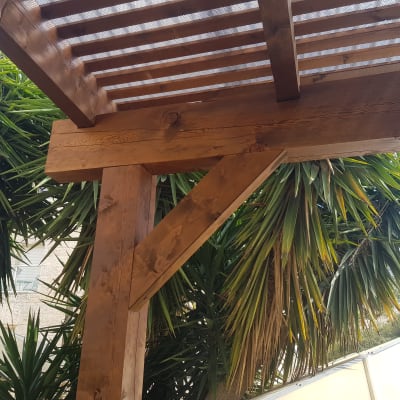 פרגולה מעץ עם קורות עץ חומות