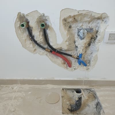 צינורות מים חשופים בקיר עם חיבורים