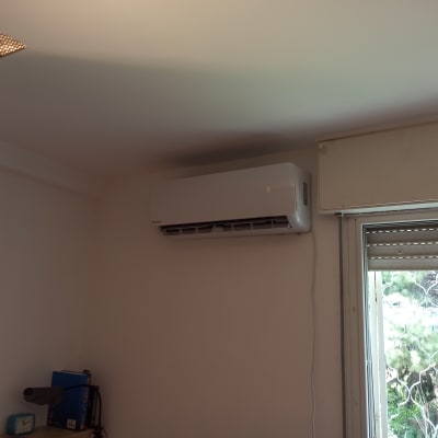 מזגן מותקן על קיר ליד חלון