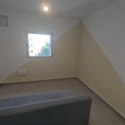 קיר צבוע בשני צבעים עם חלון קטן