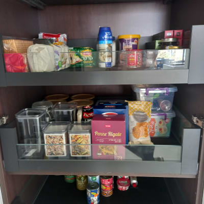 מזווה מאורגן עם מוצרי מזון, קופסאות ותבלינים