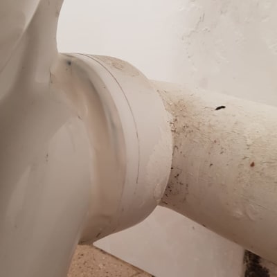 צינור ביוב לבן מחובר לקיר