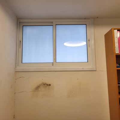 חלון אלומיניום עם מסגרת לבנה על קיר לבן