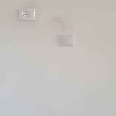 שקע חשמל על קיר לבן עם תיקונים