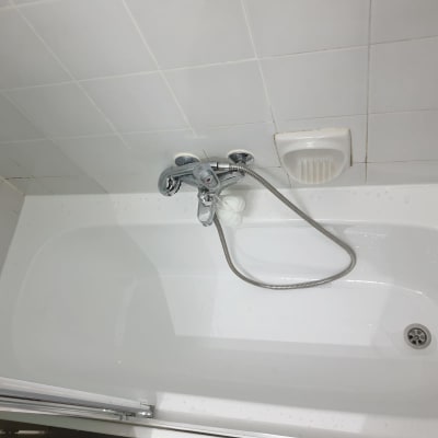 אמבטיה עם ברז ומחזיק סבון על קיר אריחים