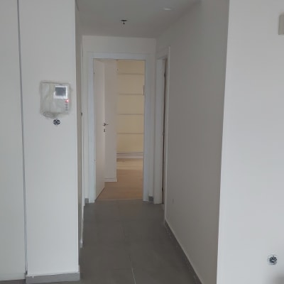 מסדרון עם קירות צבועים בלבן ודלת פתוחה