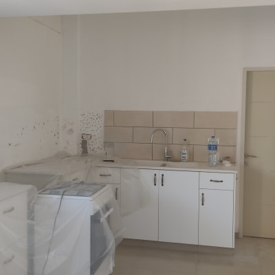 מטבח בשיפוץ עם ארונות מכוסים בניילון