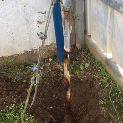 צינור חלוד עם ברז כחול מחובר לקרקע