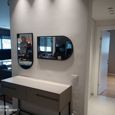 מראה עם השתקפות של אדם ליד שולחן עבודה