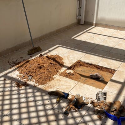 חפירה ברצפה עם כלים וכפפות על הרצפה