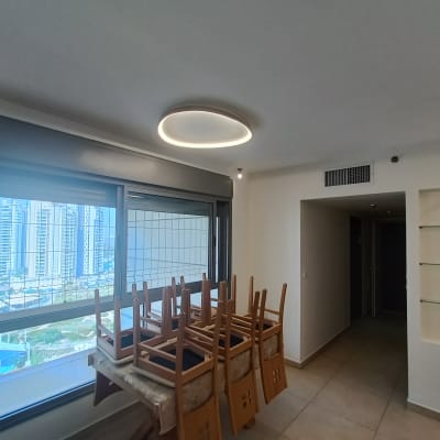 חדר עם כיסאות הפוכים על שולחן, מדפים ריקים