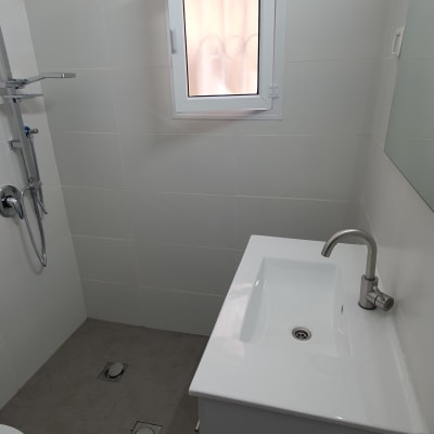 חדר אמבטיה עם כיור וברז, מקלחת וקירות נקיים