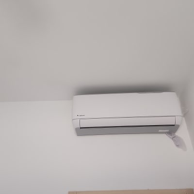 מזגן קיר לבן מותקן על קיר לבן