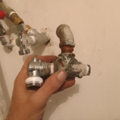 יד מחזיקה צינור מתכת חלוד עם ברזים