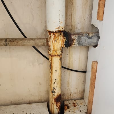 צינור חלוד עם סימני נזילה על הקיר