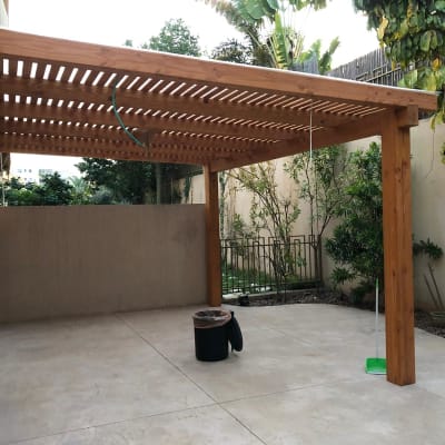 פרגולה מעץ בחצר עם רצפת בטון