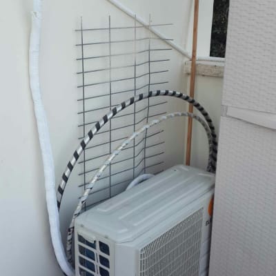 יחידת מזגן חיצונית עם צינורות מחוברים לקיר